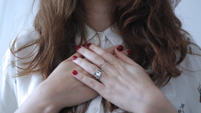 Image of a woman with hands over her heart