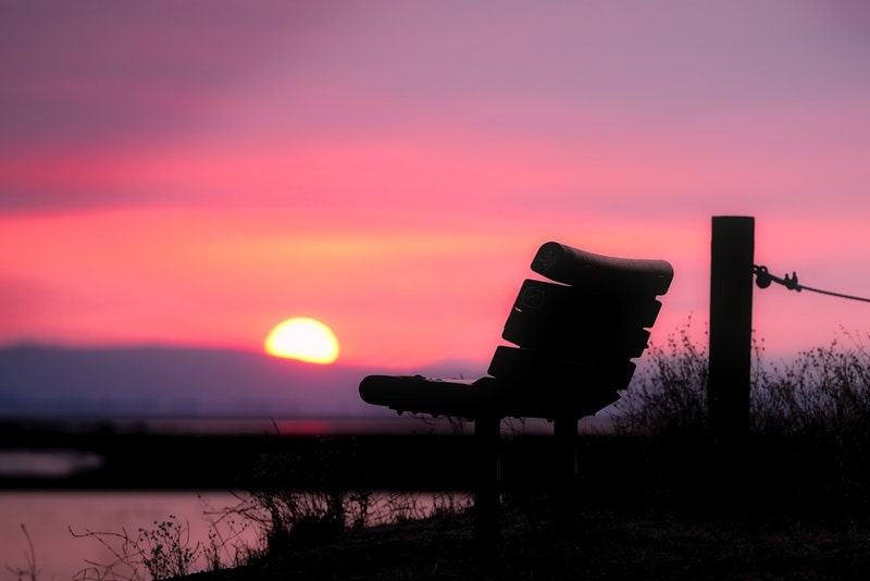 Image of a solitary seat facing the pink sunset