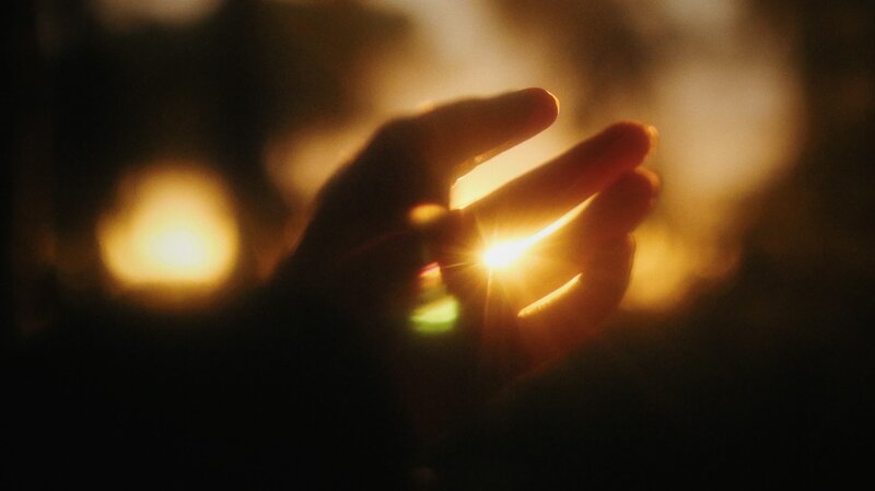 Image of a hand reaching for the sunlight symbolic of finding one's soul purpose in life