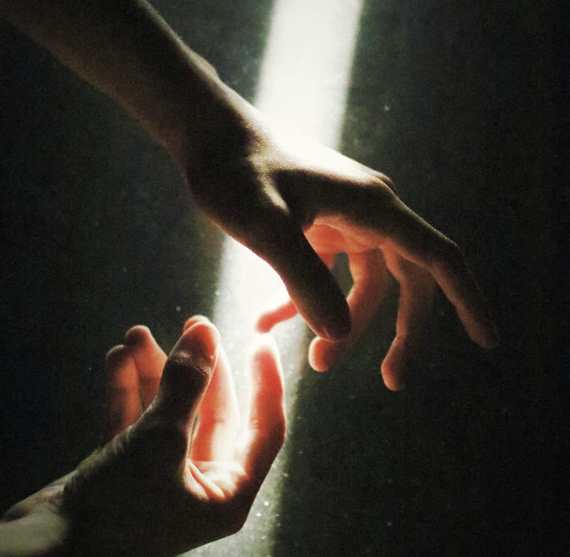 Image of hands reaching through a sunbeam