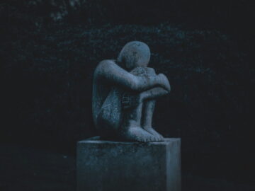 Image of a sad stone statue symbolic of emotional trauma test