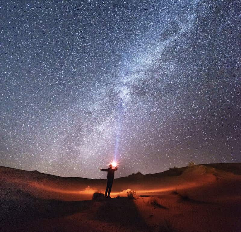 Image of a solitary person learning how to be happy alone under the stars