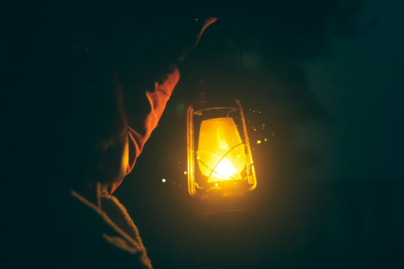 Image of someone holding a lantern in the dark