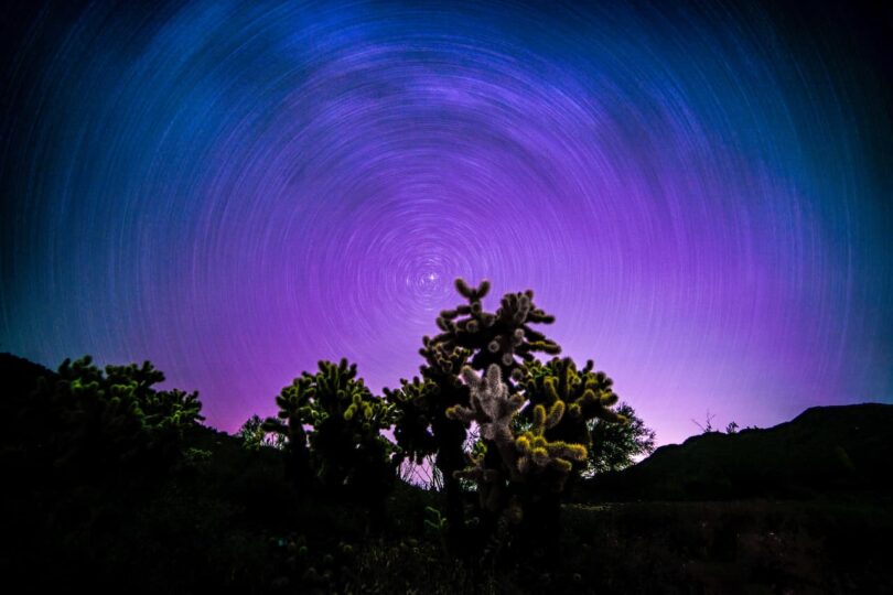 Image of a time lapsed purple night sky with stars symbolic of mystical self-inquiry