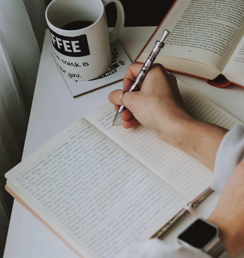 Image of a person writing in a reflective journal