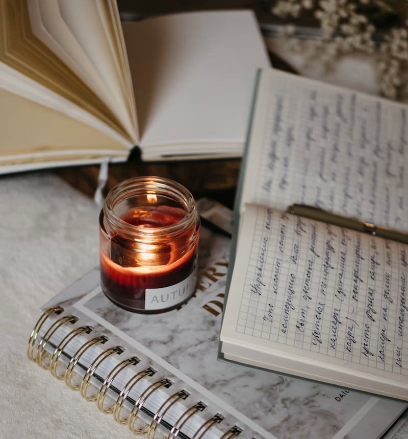 Image of a reflective journal and a red candle