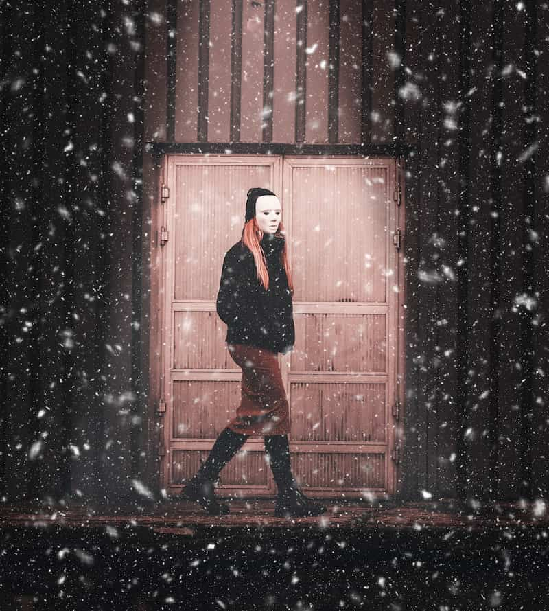 Image of a lonely and isolated person walking in the snow with a mask on