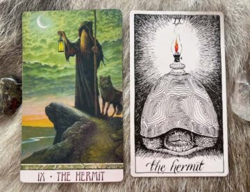 The Hermit tarot card with a figure in a hooded cloak holding a staff and lantern