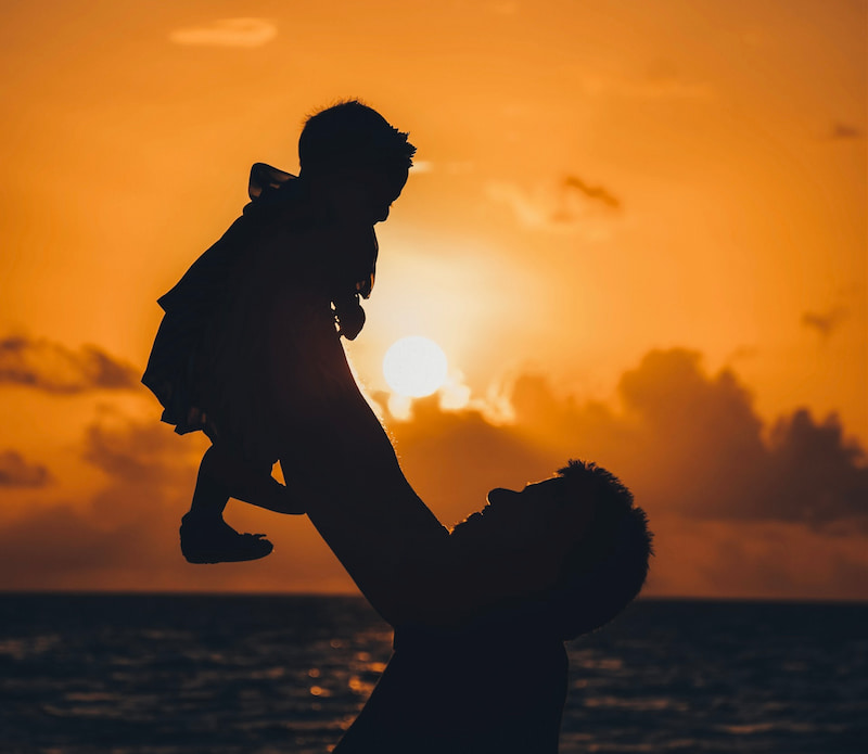 Image of a man holding up his child