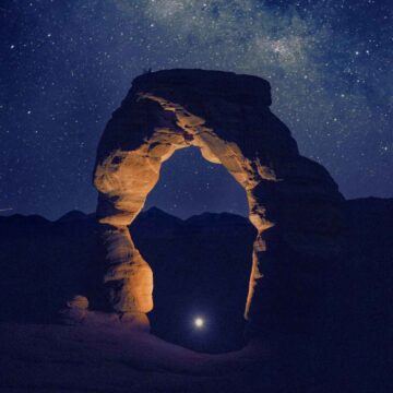 A person shining a light underneath a stone archway symbolic of finding your soul's purpose