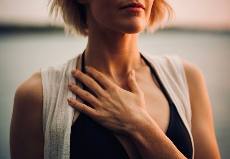 Image of a woman placing her hand over her heart