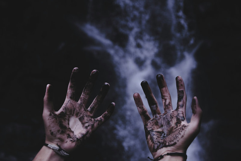 Image of  a person with black ink over their hands