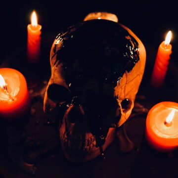 Image of a skull and candles representing alchemical nigredo