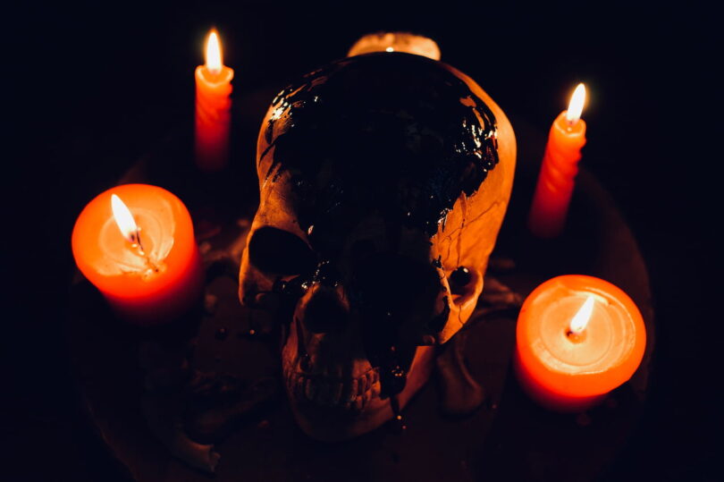 Image of a skull and candles representing alchemical nigredo