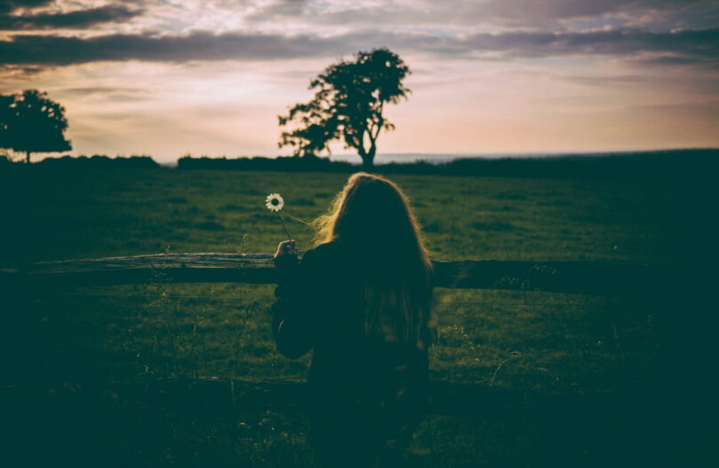 Image of someone spending time alone in front of a green pasture