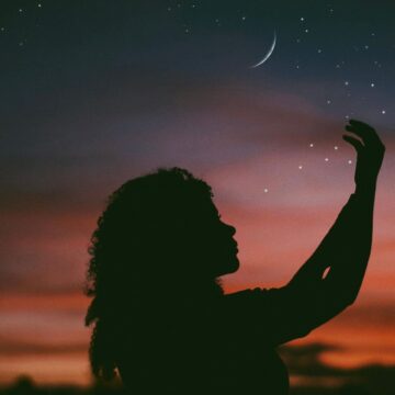 Image of a person under a crescent moon with a lone wolf mentality