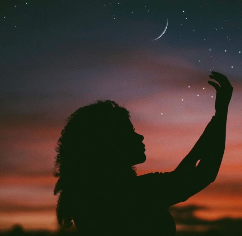 Image of a person under a crescent moon with a lone wolf mentality