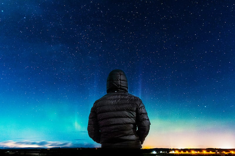 image of a person looking at the aurora borealis