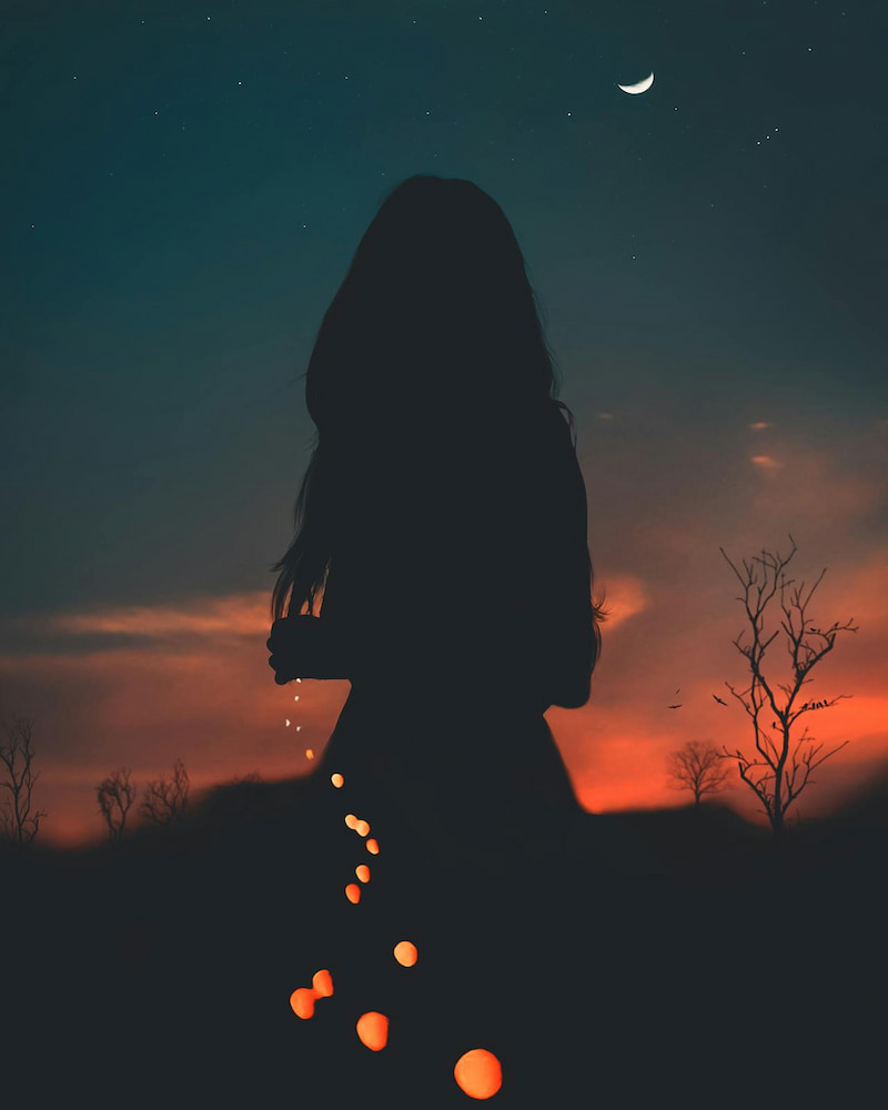 Image of a woman underneath a moon at sunset with fairy lights leading back to her heart symbolizing soul recovery