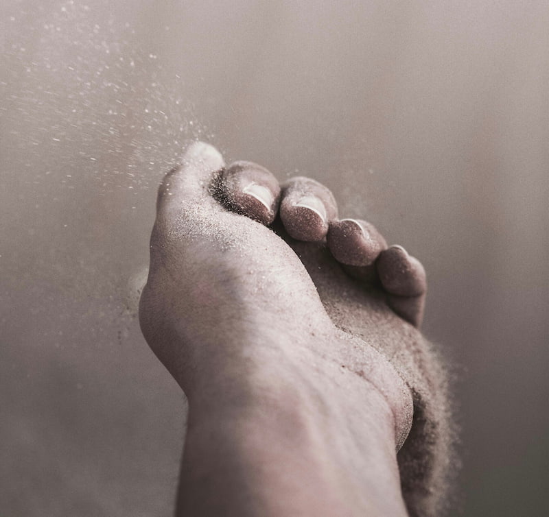 Image of a person holding sand slipping through their fingers symbolic of grief work