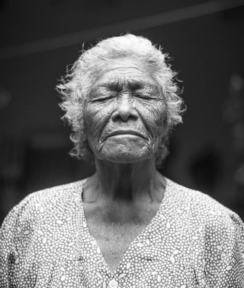 image of an old woman meditating with her eyes closed symbolic of the wisdom of the body and nervous system