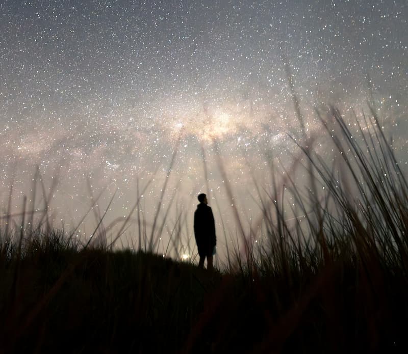 image of a solitary person standing under the stars