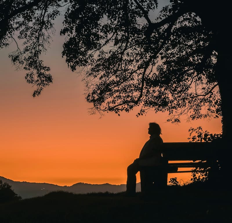 image of a person who struggles to connect with people connecting with themselves on a park bench in nature
